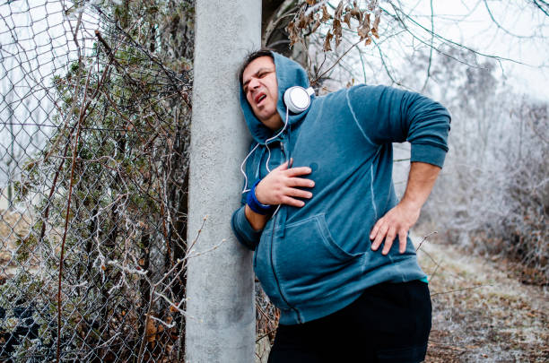 fat mature man with chest pain on jogging outdoors,taking a breath - overweight men people abdomen imagens e fotografias de stock