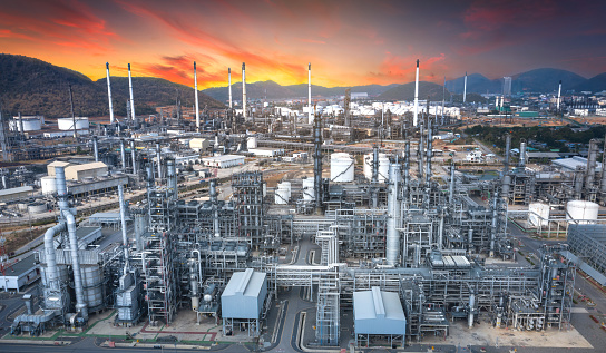 Panoramic view of the oil and gas refinery industry, with mountains in the background at dusk