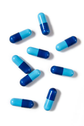 Blue medicine capsules on white background