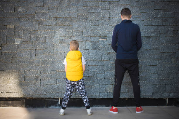 istock Back view of father and son against the wall. 1199983108