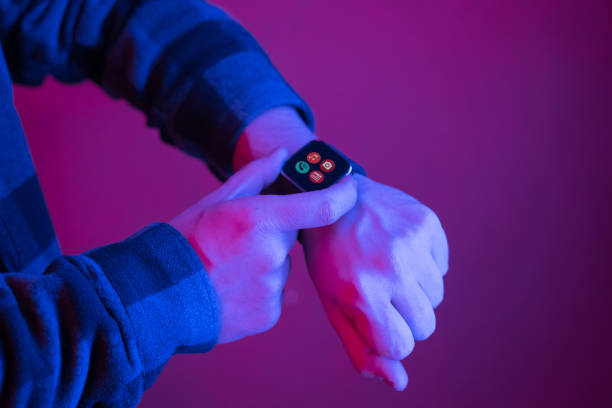 istock Close up man using wrist watch in neon light 1199984162