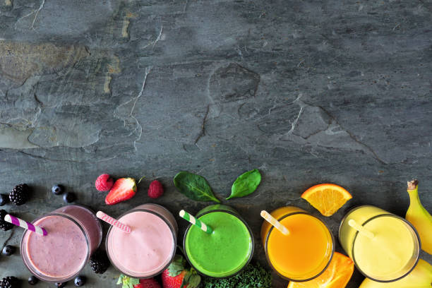 istock Assorted healthy fruit smoothies, top view bottom border against a dark background 1199985091