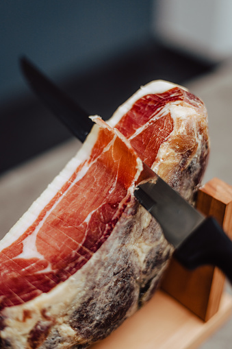 slicing slices of a spanish iberian serrano ham.