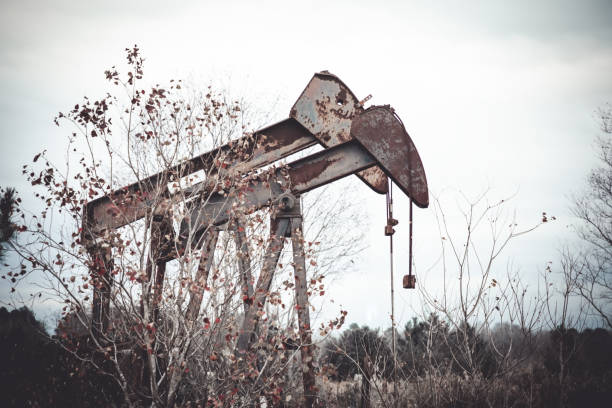 rural texas - bombas de aceite abandonadas por rusty - pozo de petróleo fotografías e imágenes de stock