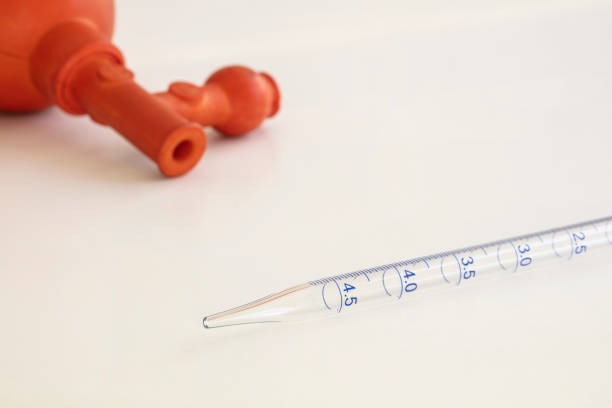 Laboratory Volumetric Glass Pipette and a Pipette Bulb Isolated on White