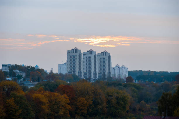 istock Houses under the sunset, orange clouds over multi-storey buildings 1199987765