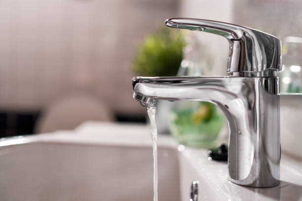 istock Cold water flowing from faucet in clean bathroom 1199988807