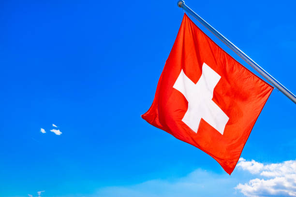 istock Switzerland flag, blue sky and clouds. 1199989688