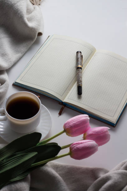 istock Open Diary, Pen, Cup With Hot Coffee, Scarf, Tulips on the White Background. Spring Concept. Flat lay, top view 1199990327