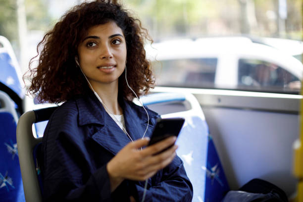istock Young woman using mobile phone on the bus 1199990416