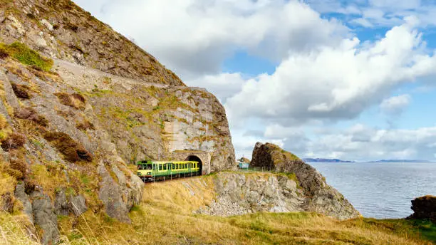 Train exiting a tunnel. View from Cliff Walk Bray to Greystones with beautiful coastline, cliffs and sea, Ireland