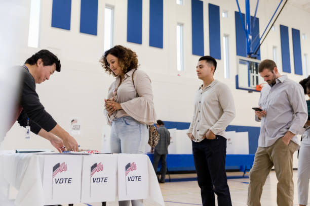 istock People wait to sign in while someone votes in background 1199991195
