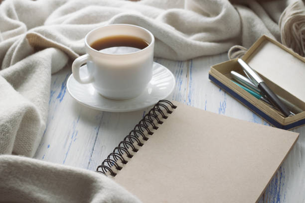 istock Cup with Coffee, Notepad, Pens on the White Wooden Table. Concept of Spring 1199993385