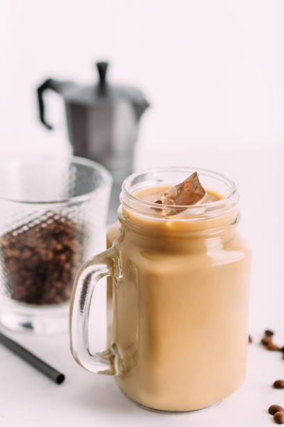 Cold brewed iced coffee in glass jar and coffee beans in glass