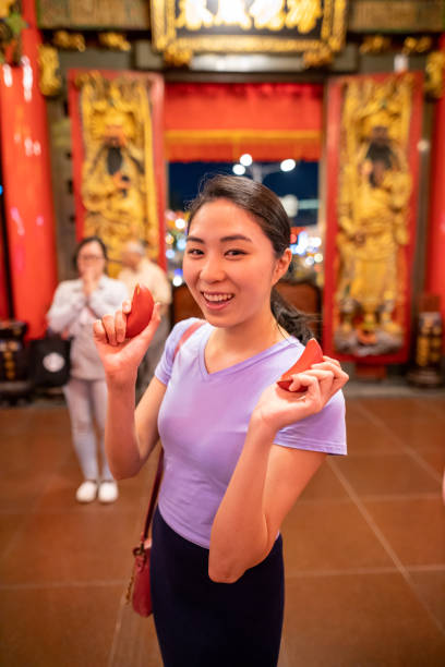 Young woman throwing moon blocks for good fortune