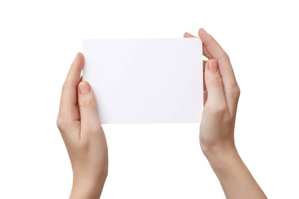 istock Female hands holding blank paper postcard isolated on white 1200004098