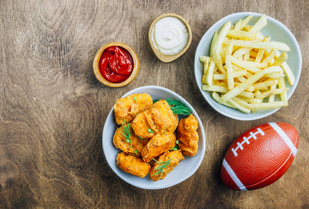 mesa fof lanches saborosos e cerveja preparada para assistir esportes na tv. fundo de madeira. vista superior. lay liso - american football football food snack - fotografias e filmes do acervo