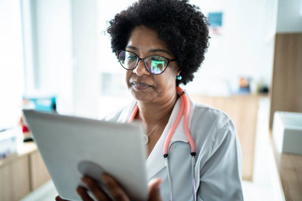 istock Mature female doctor using digital tablet at medical office 1200010115