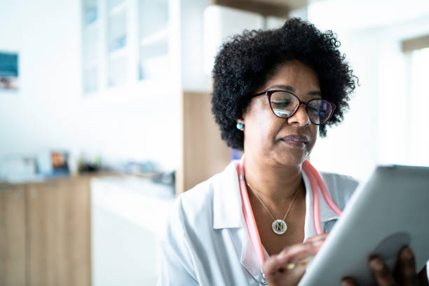 istock Mature female doctor using digital tablet at medical office 1200010161