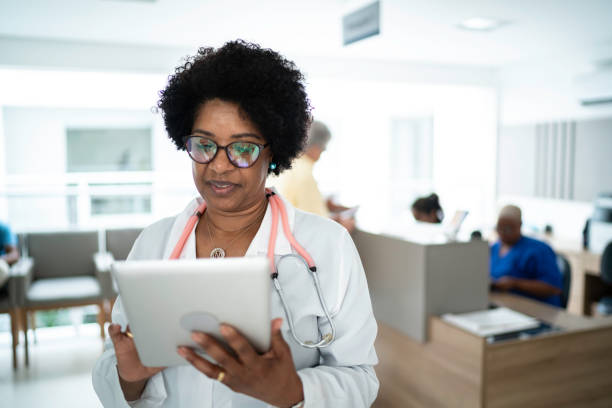 Mature female doctor using digital tablet at medical office