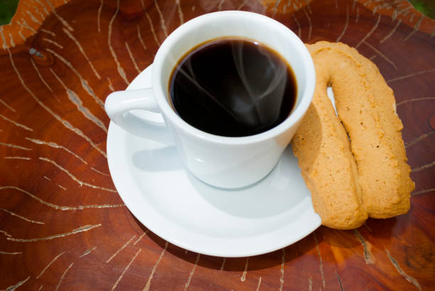 istock Cup of coffee accompanied by toast or cookie called Herraje, typical tablecloth on wooden table. 1200016831