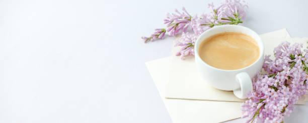 istock Minimal elegant composition with coffee cup and lilac branches, envelope on white background, female morning breakfast, woman mother day, saint valentine day, wedding 1200020239