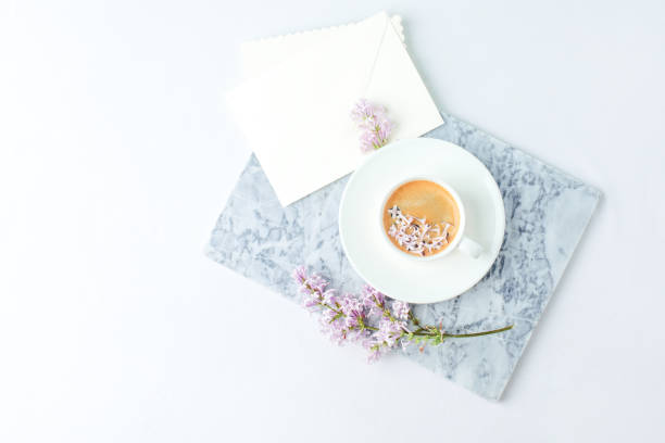 istock Minimal elegant composition with coffee cup and lilac branches, envelope on white background, female morning breakfast, woman mother day, saint valentine day, wedding 1200020242