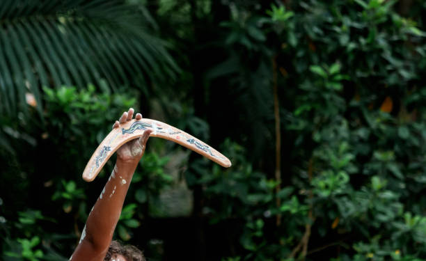 danza tradizionale della cultura aborigena australiana con vernice per il corpo e boomerang di tenuta delle mani - outback australia australian culture land foto e immagini stock