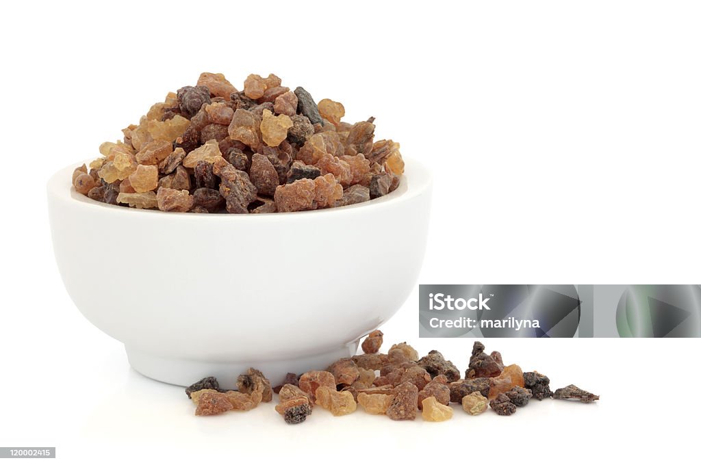 A white bowl full of dried fruits Myrrh oleo gum resin in a porcelain mortar and scattered, over white background. Myrrh - Resin Stock Photo