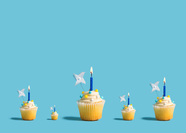 istock Big and small cupcakes with lit candles 1200027235