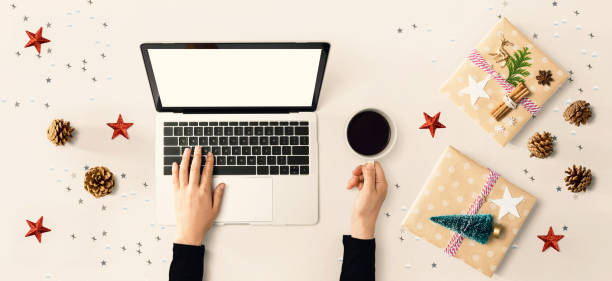 istock Christmas ornaments with person using a laptop computer 1200027312