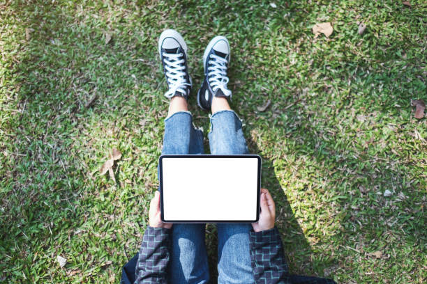 istock a woman holding and using black tablet pc with blank white desktop screen while sitting in the outdoors 1200033449