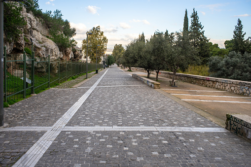 Athens, Greece, Dionysiou Areopagitou street, early morning with no people.  Pedestrian walkway under acropolis hill.