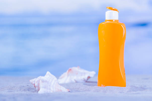 istock Orange sunscreen bottle with a pair of seashells 1200046668