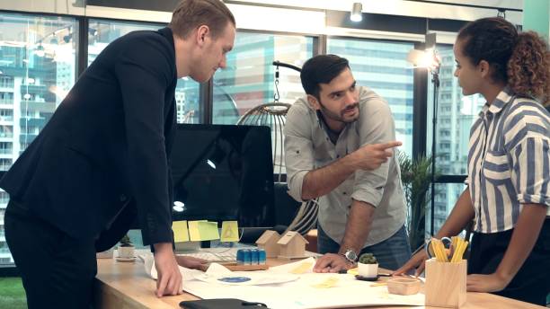 istock Creative business people group having conversation at office desk in workplace. 1200046720