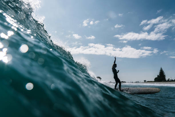 surfer girl och the barrel wave - longboarding surfing bildbanksfoton och bilder