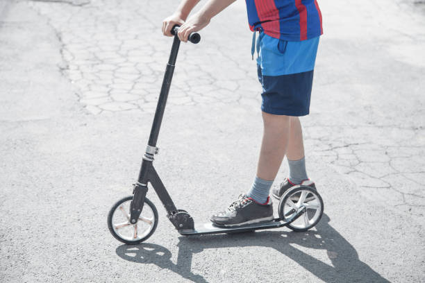 istock Boy on a scooter riding on the street. 1200047665