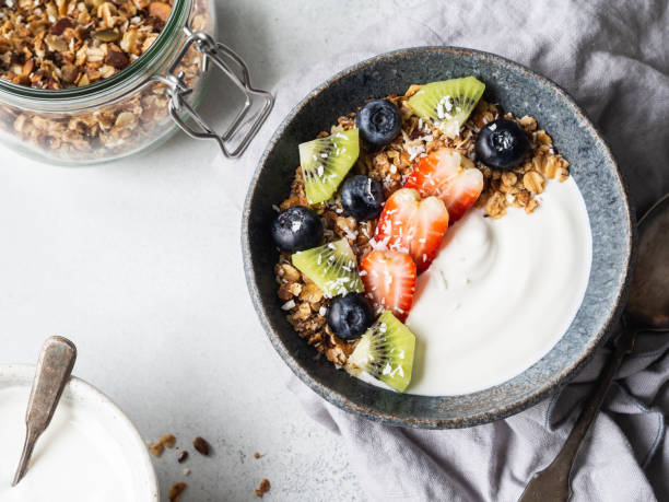 istock Delicious breakfast - granola in bowl with yogurt, fruit and berries on the table. Top view 1200048845