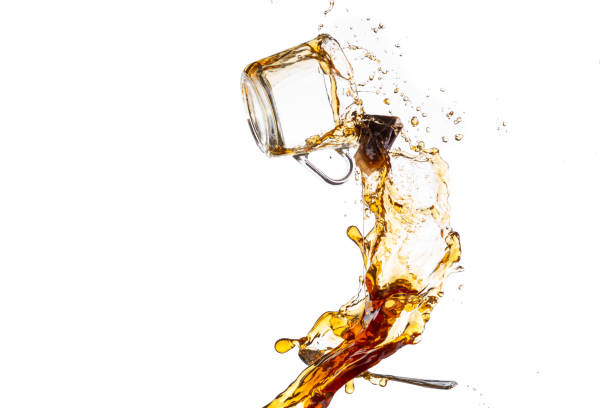 istock transparent mug with black tea turned upside down and falls with a splash and spray 1200049053