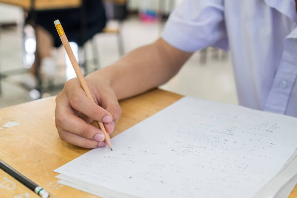 istock hand student testing in exercise taking fill in exam carbon paper answer sheet with pencil at school or university in test room, document exams at campus classroom, education or back to school concept 1200050704