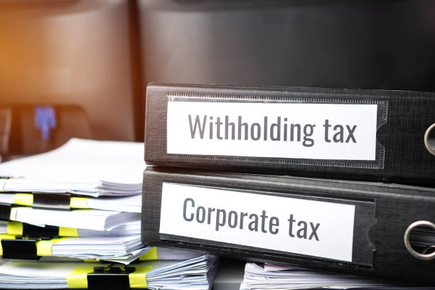 Stack of taxes binders report concept: Document of Withholding tax and corporate tax for accountant. withholding tax sometimes applies to royalties, rent or even sale duty must be paid to government concepto de informe de aglutinantes de pila de impuestos: documento de retención de impuestos e impuesto de sociedades para contable. retención de impuestos a veces se aplica a las regalías, alquiler o incluso el derecho de venta debe ser pagado al gobi