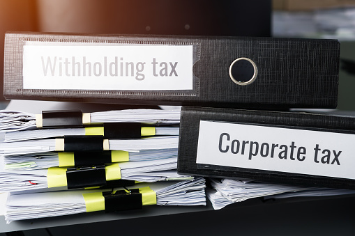 Tax concept, Withholding taxes binders files on document report in business office. Retention taxes is income tax to be paid to government by payer of income rather than by recipient of the income.