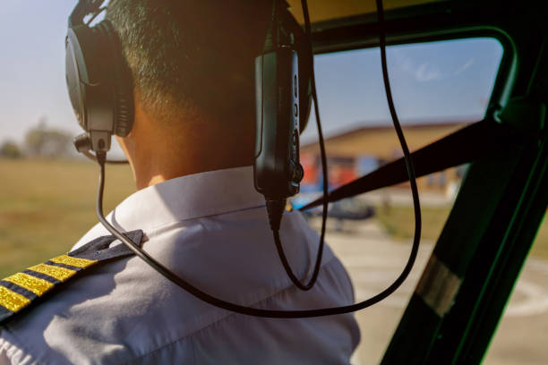 istock Helicopter pilot with headphones on waiting to take off 1200052230