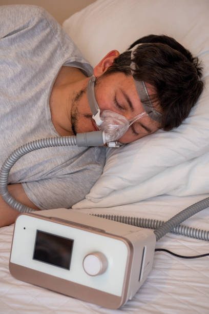 istock Healthy young man wearing ( CPAP Mask ) nasal mask and using CPAP machine for sleeping smoothly all night 1200053386