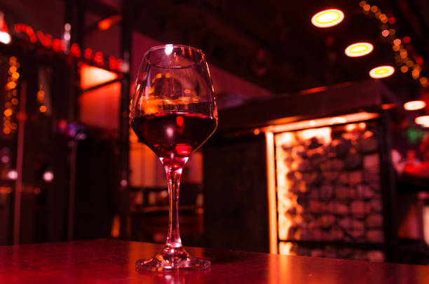istock Glass of red wine on backlighted background 1200053526