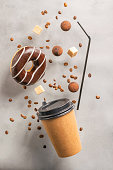 einweg-papierbecher-mit-einem-donut-getr