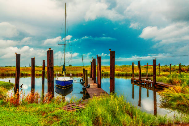 barca agganciata nel canale - swamp moody sky marsh standing water foto e immagini stock