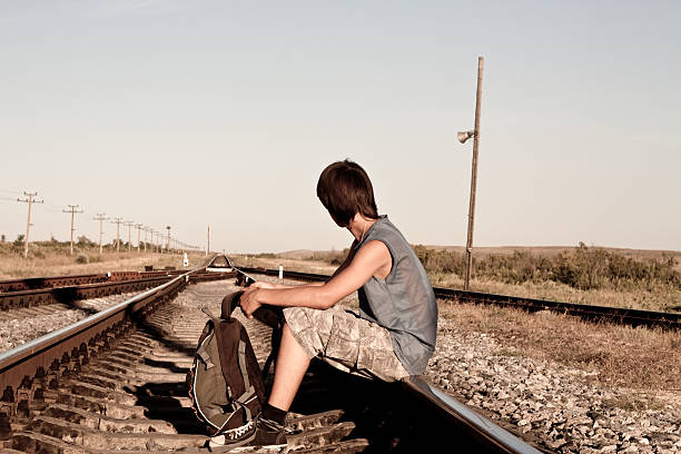 istock Teen boy with problems siting on rail road 120005572