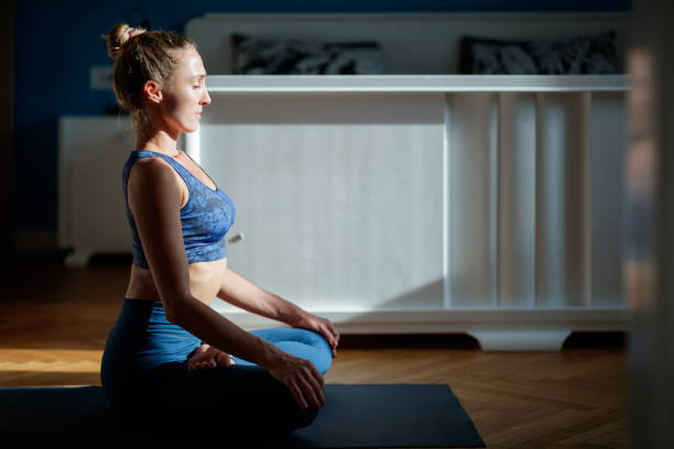 istock Serene woman meditating at home 1200057107