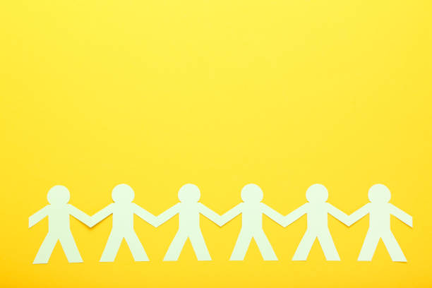 istock Paper chain people on yellow background 1200057452